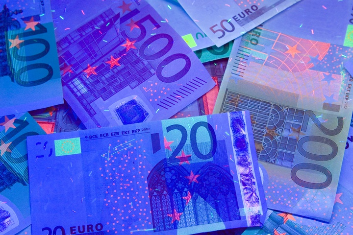 Geldscheine im blauen Neonlicht  - Copyright: istock.com/kazina